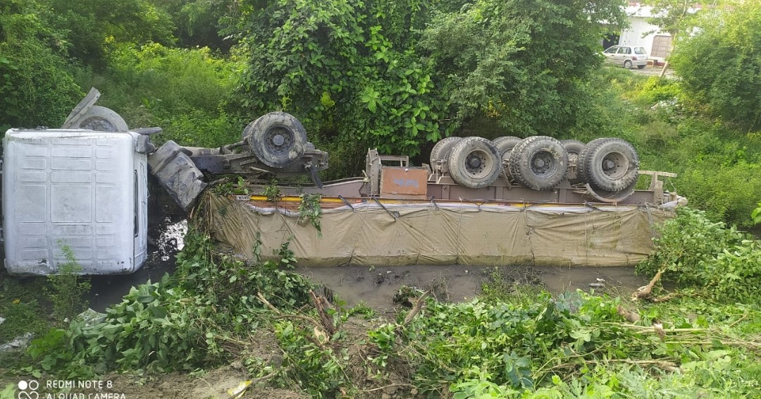 गड्ढे मे पलटा ट्रक बाल बाल बचा ड्राइवर